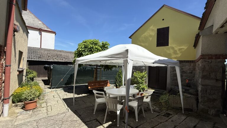 Dvůr s posezením pod stanem